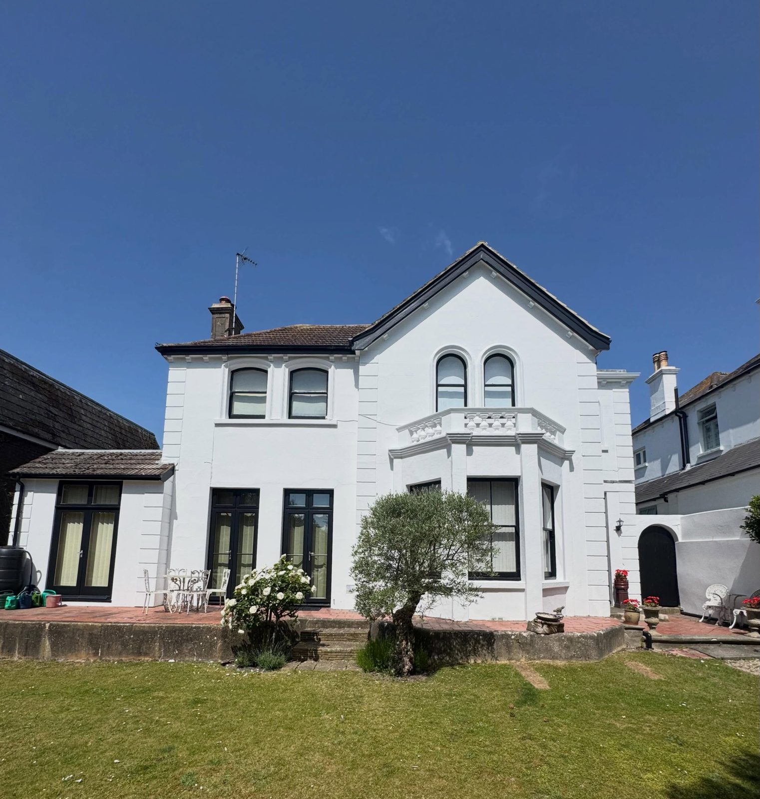 White rendered detached house with freshly painted windows and doors under a blue sky